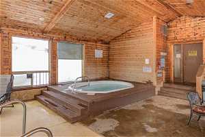 Miscellaneous room with a jacuzzi, vaulted ceiling, wooden walls, and wooden ceiling