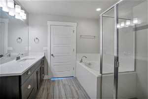 Bathroom featuring plus walk in shower and large vanity