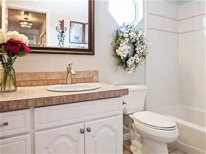 Full bathroom with vanity, toilet, tile flooring, and shower / bath combination