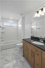 Full bathroom with tile flooring, oversized vanity, toilet, and washtub / shower combination