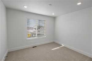 Unfurnished room featuring light carpet