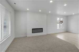 Unfurnished living room with light carpet