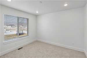 Empty room featuring light carpet and plenty of natural light