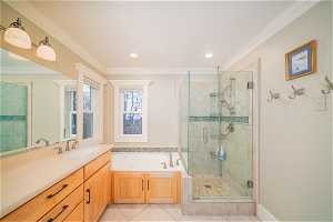 Bathroom with tile flooring, crown molding, plus walk in shower, and large vanity