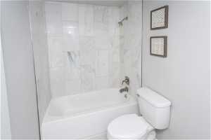 Bathroom with toilet and tiled shower / bath