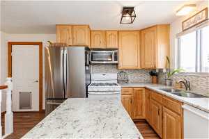 Kitchen featuring backsplash, dark wood-type flooring, sink, and light brown cabinets