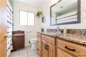 updated full bath with tile floors, toilet, and oversized vanity