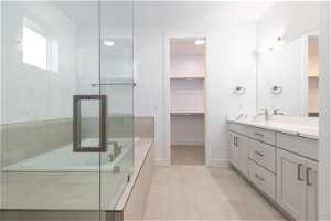 Bathroom with tile flooring, vanity with extensive cabinet space, and an enclosed shower