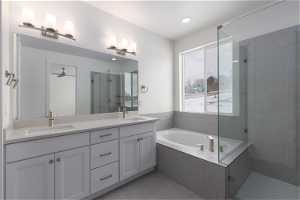 Bathroom featuring double vanity, shower with separate bathtub, tile flooring, and ceiling fan