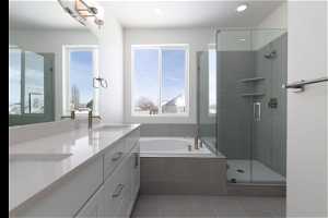 Bathroom featuring double vanity, separate shower and tub, and tile floors