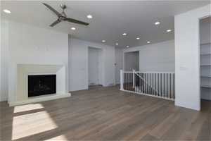 Unfurnished living room with ceiling fan and dark wood-type flooring