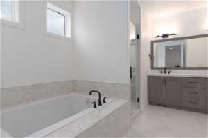 Bathroom with tile flooring, independent shower and bath, and large vanity