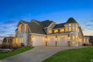View of front of property featuring a front yard, driveway, and stone siding