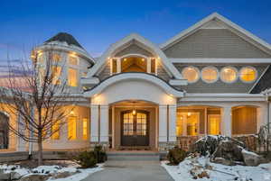 View of front of home with french doors, a porch, stone siding, and stucco siding
