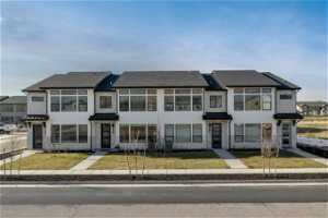 Townhome / multi-family property with a front lawn