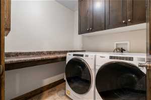 Laundry room featuring cabinets, independent washer and dryer, light tile flooring, and hookup for a washing machine