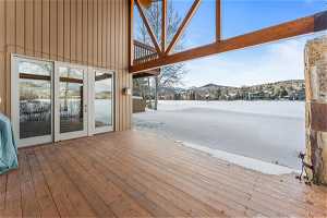 Snow covered deck with french doors
