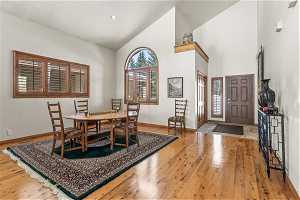 Dining room featuring light hardwood / wood-style floors and high vaulted ceiling