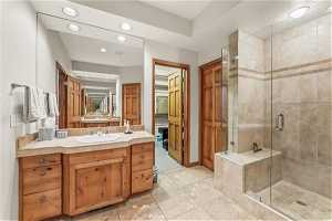 Bathroom with tile floors, vanity, and walk in shower