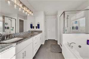 Bathroom with tile flooring, plus walk in shower, and double vanity
