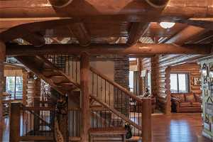Stairway featuring dark wood-type flooring, beam ceiling, log walls, and wood ceiling