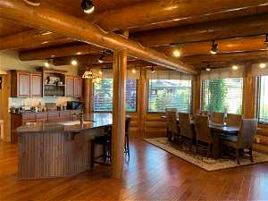 Dining area featuring dark hardwood / wood-style floors, beam ceiling, wooden ceiling, and sink
