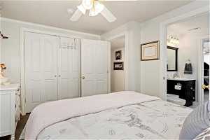 Carpeted bedroom featuring ensuite bathroom, a closet, sink, and ceiling fan