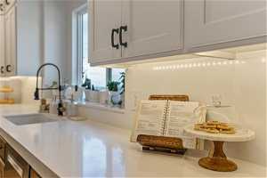 Kitchen with white cabinetry, a healthy amount of sunlight, and sink