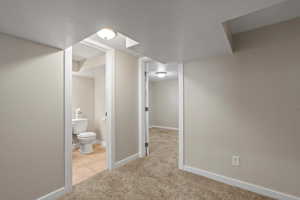 Corridor with light tile flooring and a textured ceiling
