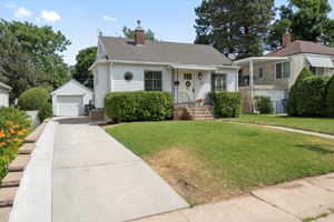 View of front of property with a front lawn, a detached garage.