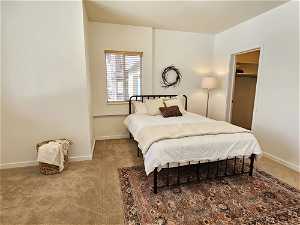 Bedroom with light colored carpet, a closet, and a spacious closet