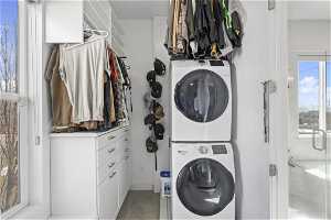 Primary suite custom closet featuring stacked washer and clothes dryer