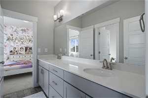 Bathroom with dual sinks, tile flooring, and oversized vanity