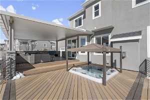 deck with hot tub and outdoor lounge area