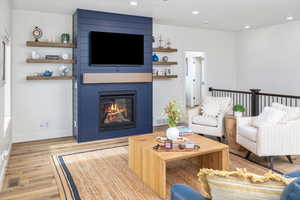 Living room featuring a large fireplace and light LVP flooring