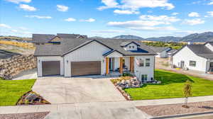 Modern farmhouse style home featuring a mountain view, a garage, and a front lawn