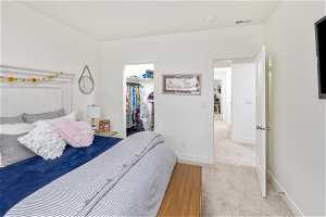 Carpeted bedroom with a spacious closet and a closet