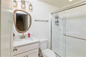 Bathroom with walk in shower, toilet, and oversized vanity