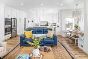 Living room with an inviting chandelier and light LVP floors