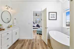 Master bathroom featuring LVP flooring, a bathing tub, vanity