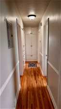 Corridor featuring a textured ceiling and light hardwood / wood-style floors