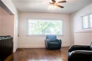 Living area featuring dark hardwood / wood-style floors, ceiling fan, and radiator