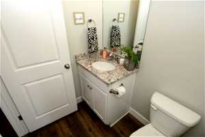 Bathroom featuring hardwood / wood-style flooring, toilet, and oversized vanity