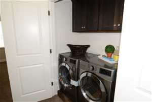 Laundry area featuring cabinets, separate washer and dryer, and dark carpet