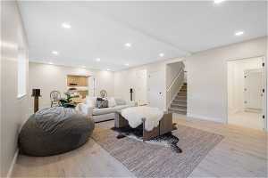 Primary basement living room with light hardwood / wood-style flooring