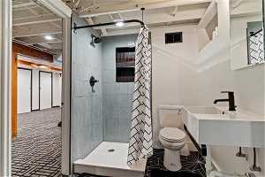 Bathroom featuring toilet and a shower with shower curtain