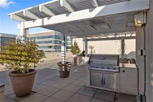View of terrace with an outdoor kitchen, a grill, and a pergola