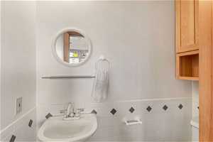 Bathroom featuring sink and tile walls