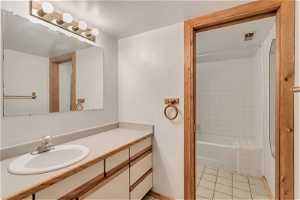 Bathroom featuring tile flooring, tiled shower / bath, and oversized vanity