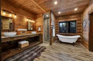 Bathroom with double sink vanity, wooden walls, wood ceiling, and hardwood / wood-style floors